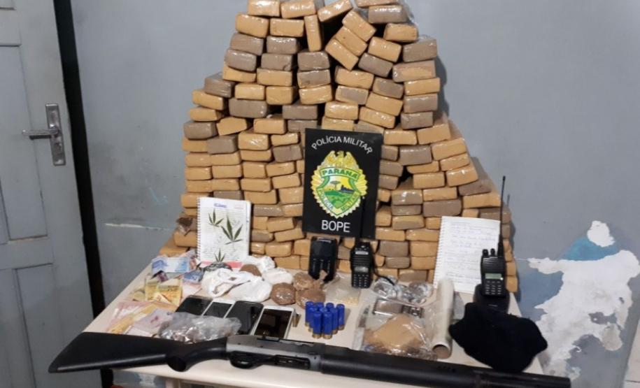Uma espingarda, munições, dinheiro, 850 gramas de crack e mais de 98 quilos de maconha foram apreendidos por policiais militares da Rondas Ostensivas de Natureza Especial (RONE), subunidade do Batalhão de Operações Especiais (BOPE).